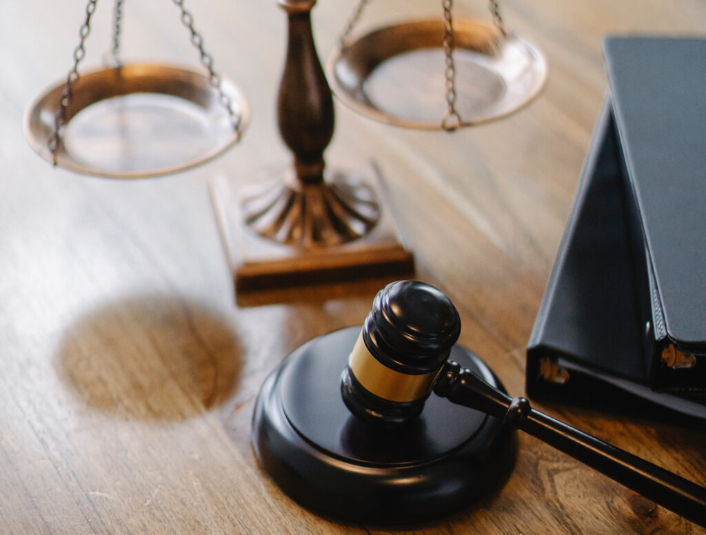 Gavel, scales, and binders resting on a table